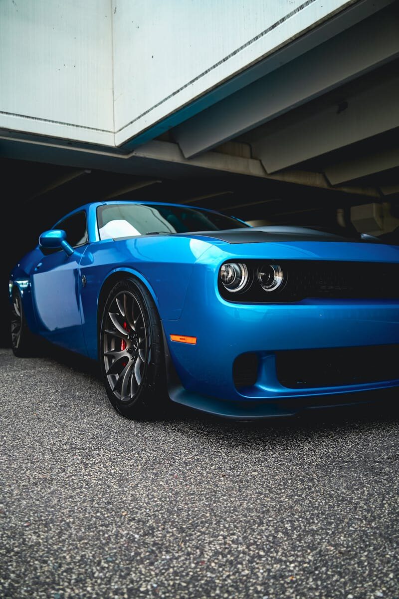 Stylish blue sports car parked under a city overpass, showcasing modern design.